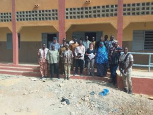 Photo de groupe devant un bâtiment scolaire au CEG de Kiri, commune de Tenkodogo, prise lors d'une mission de suivi du projet FDCIII avec des représentants locaux et des partenaires techniques.